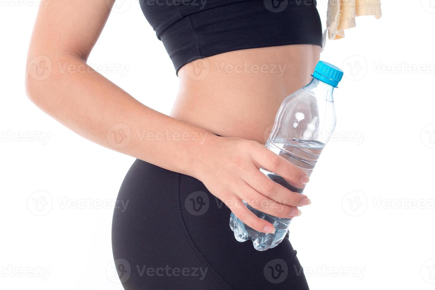 Sportmädchen, das eine Flasche Wasser in der Hand hält foto