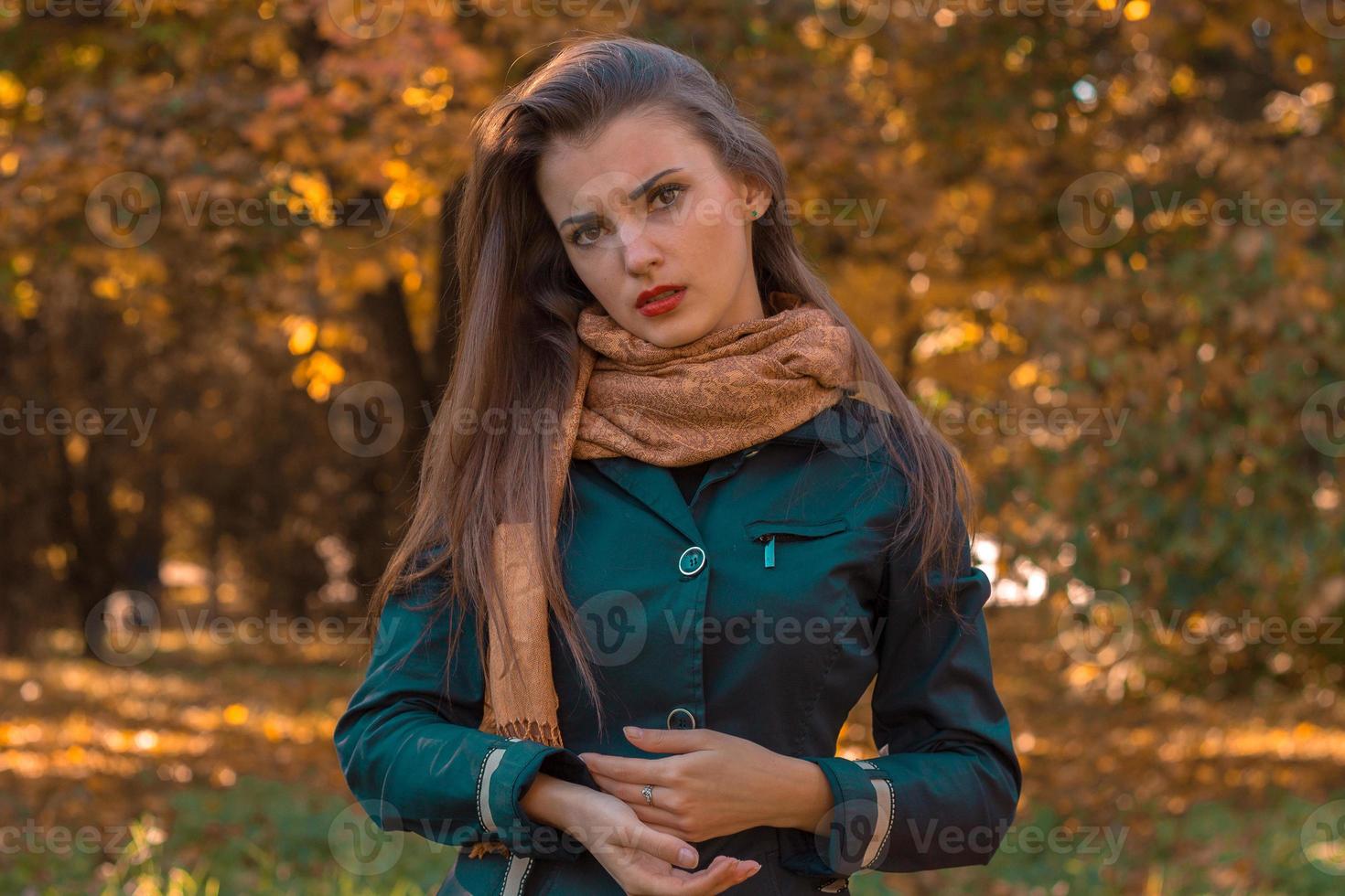 ernsthaftes junges Mädchen in einer schwarzen Jacke steht im Herbstpark foto
