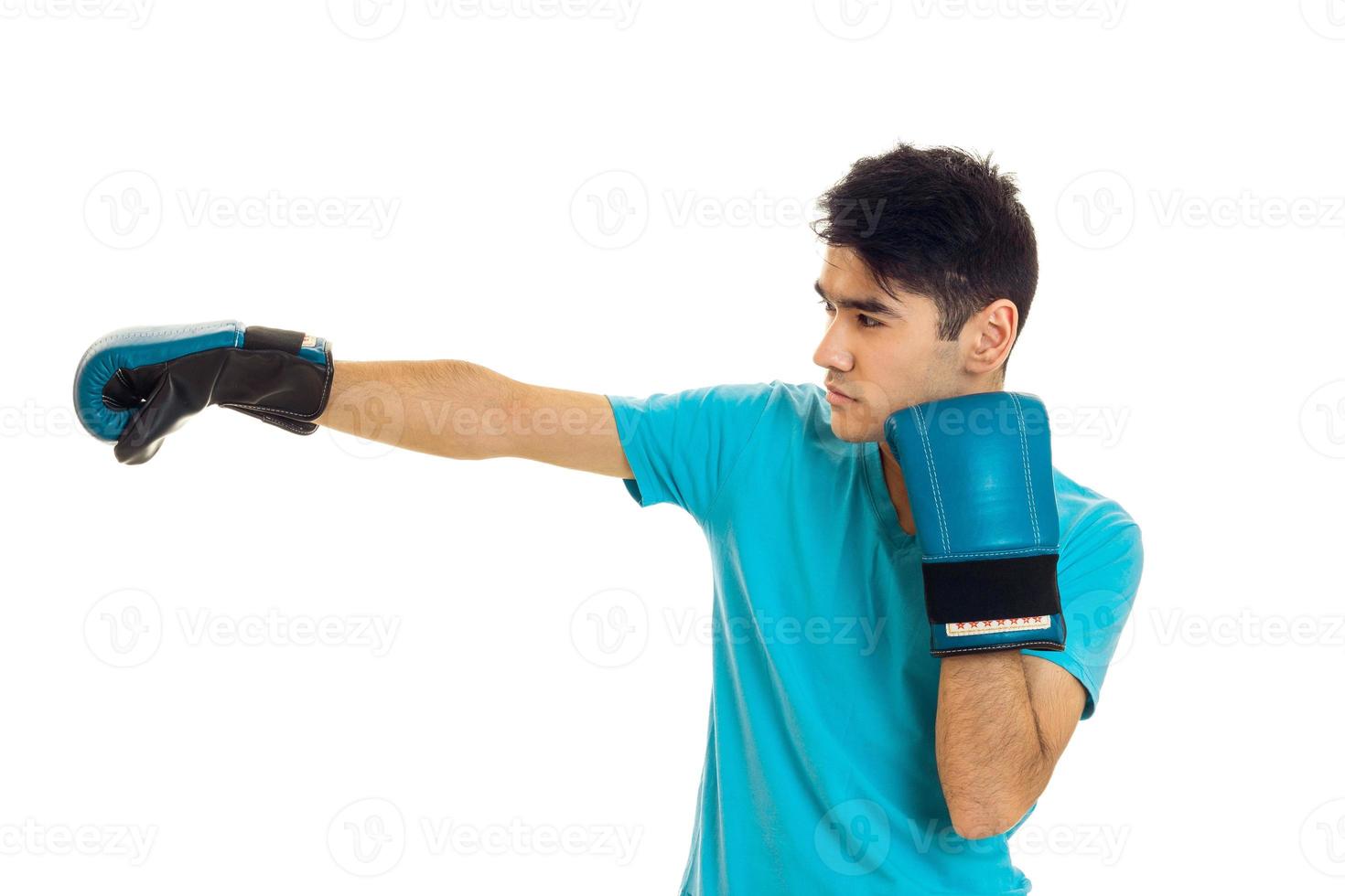 starker brünetter Sportler, der das Boxen in blauen Handschuhen einzeln auf weißem Hintergrund betreibt foto