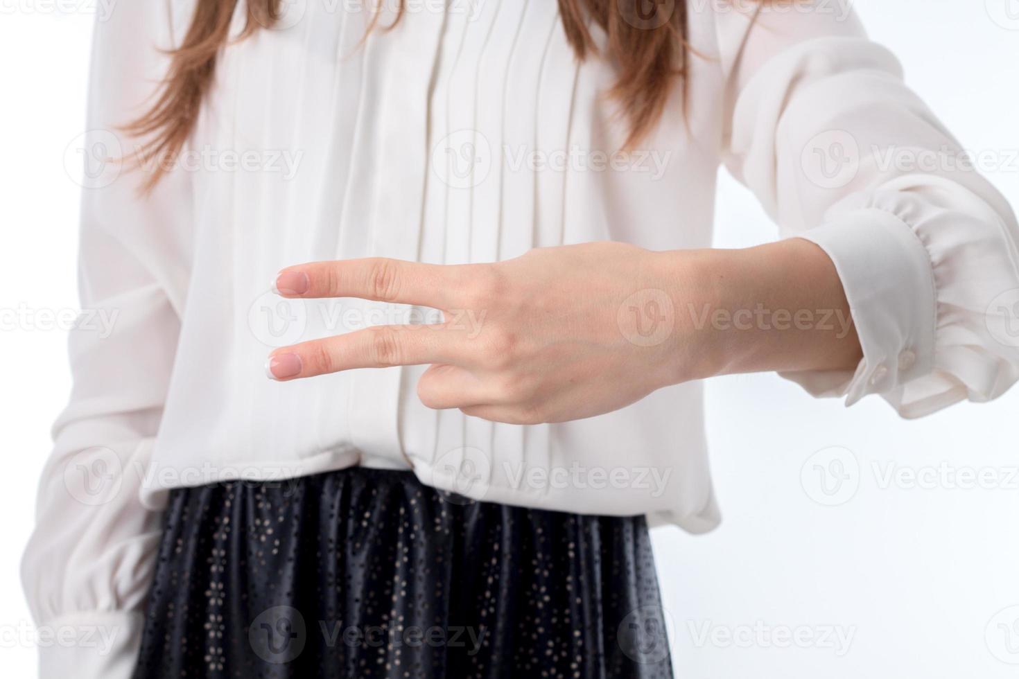 Das Mädchen streckt die Hand aus und hält sich die zwei Finger heran foto