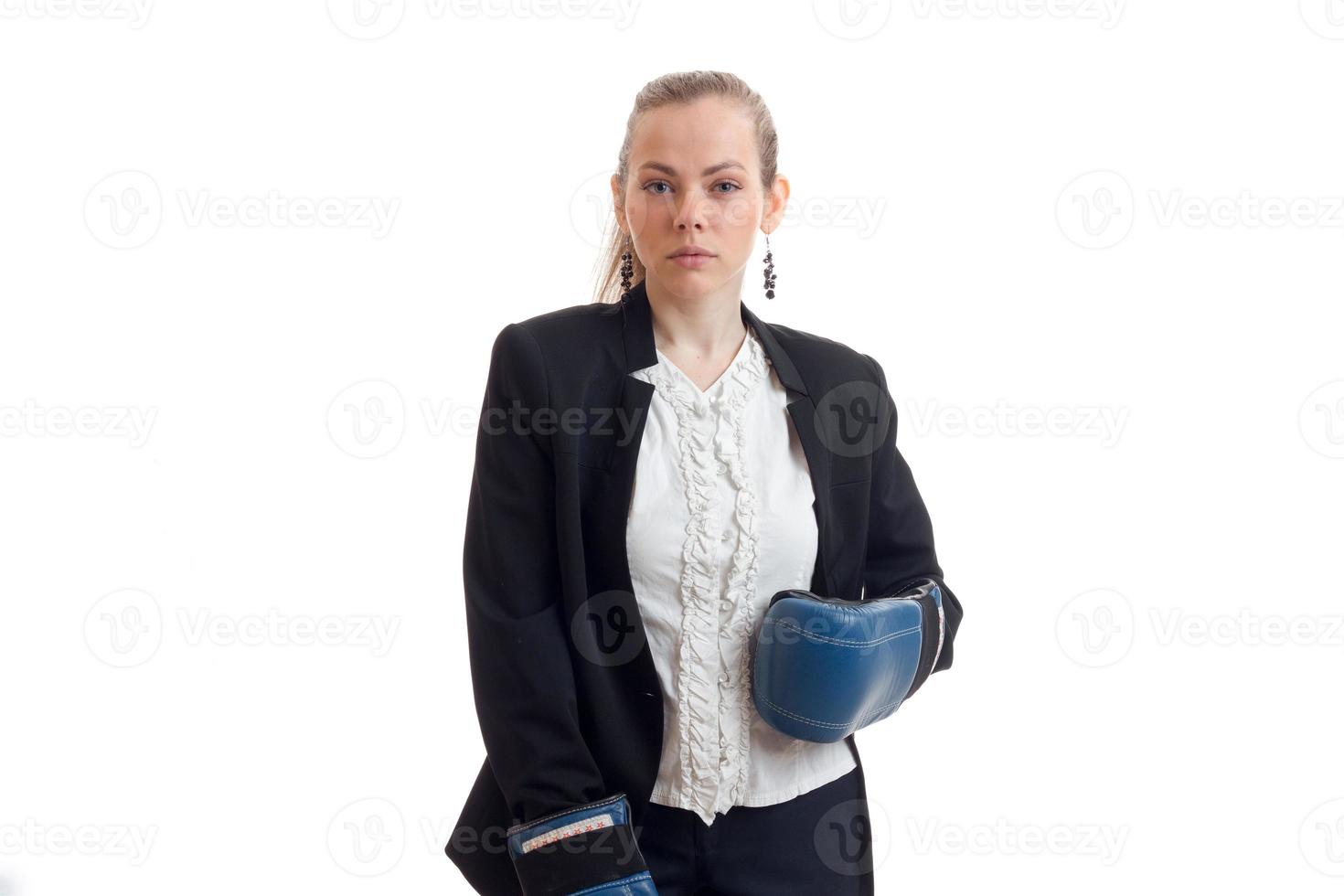 Mädchen in Jacke und Hemd, das in Boxhandschuhen vor der Kamera posiert foto