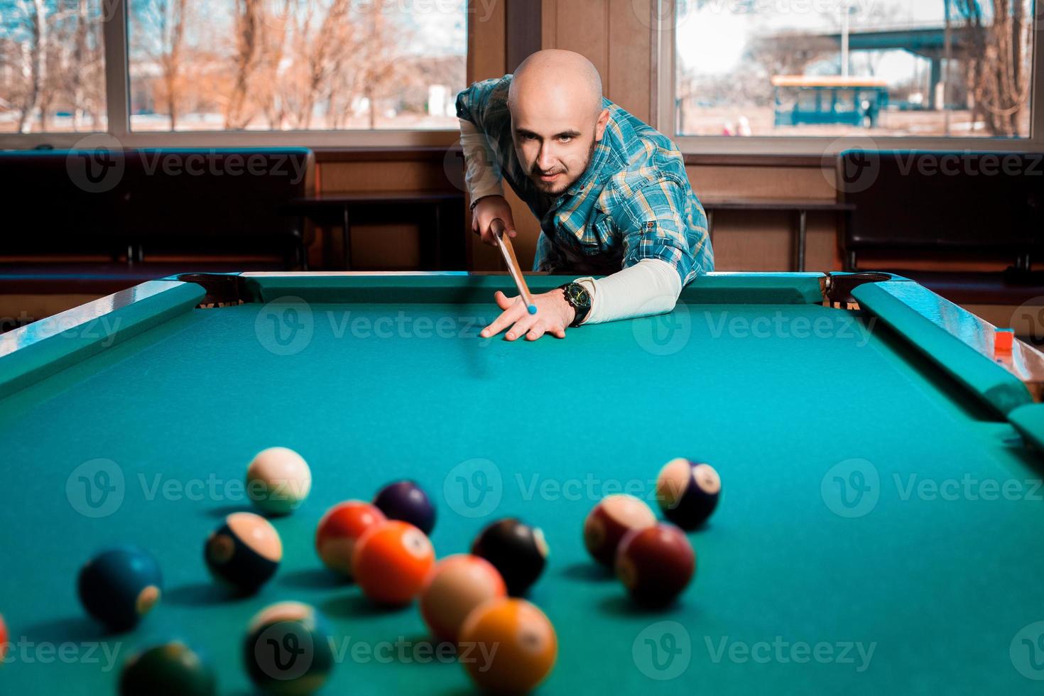 netter junger Kerl spielt Billard foto