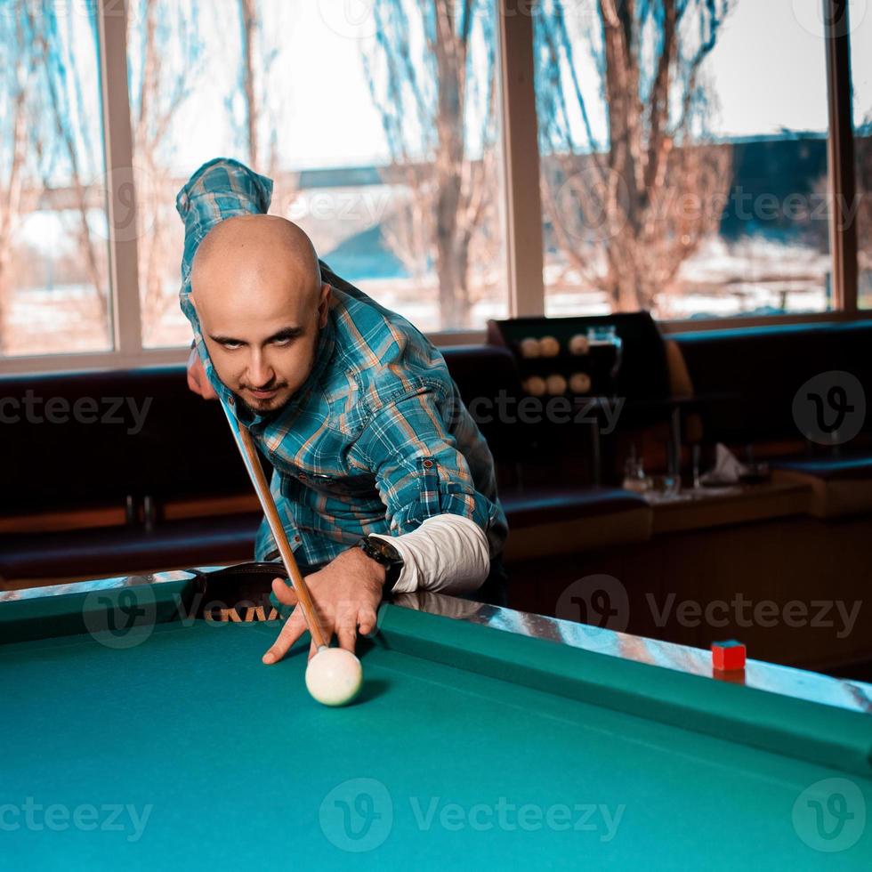 quadratisches Foto Mann, der sich darauf vorbereitet, die Spielkugel auf einem Pool-Billard zu schlagen