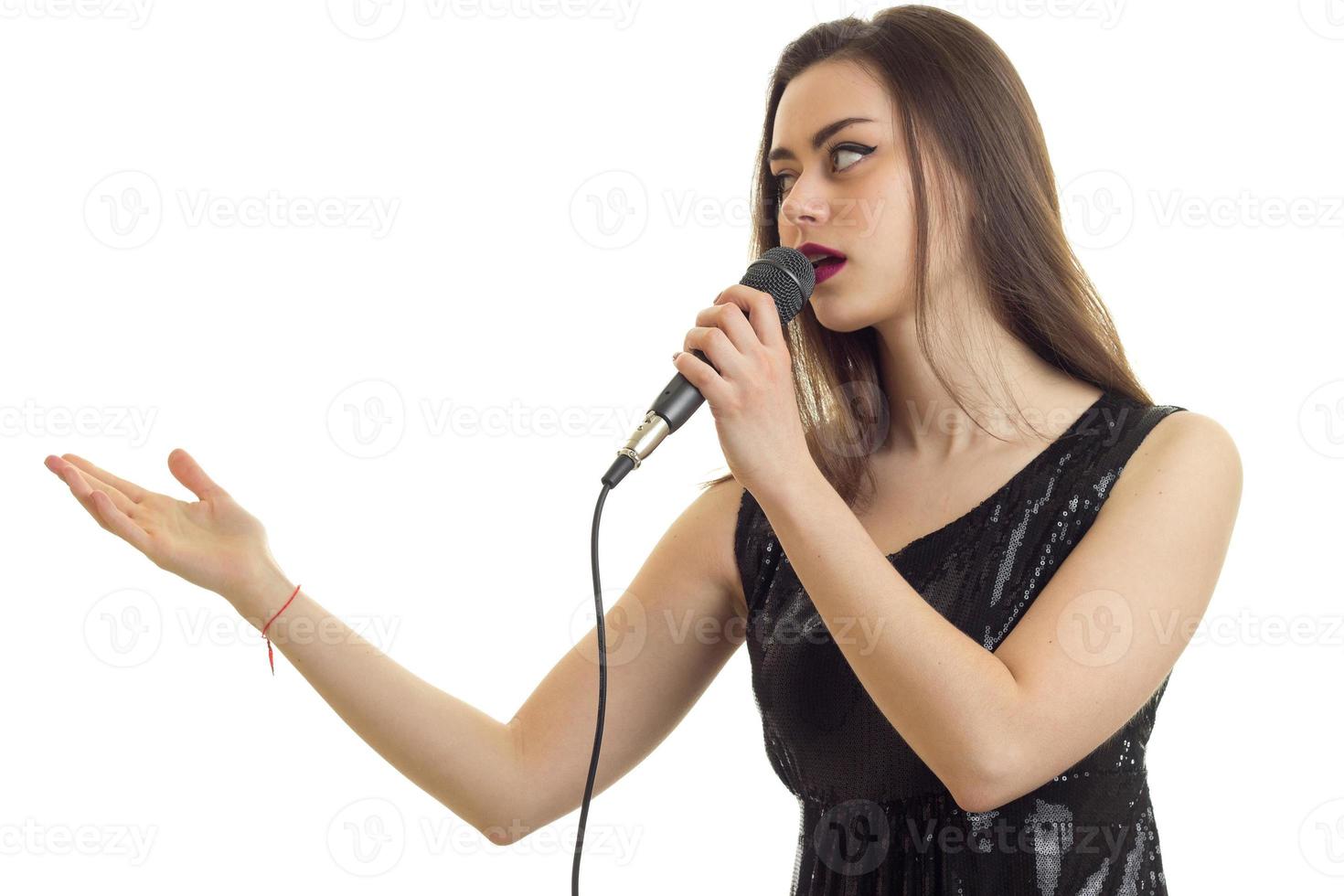 Schöne junge Frau singt Karaoke foto