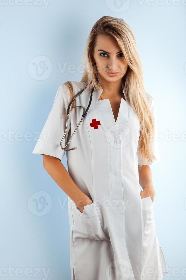 Krankenschwester mit blonden Haaren im Arztkittel mit Stethoskop foto