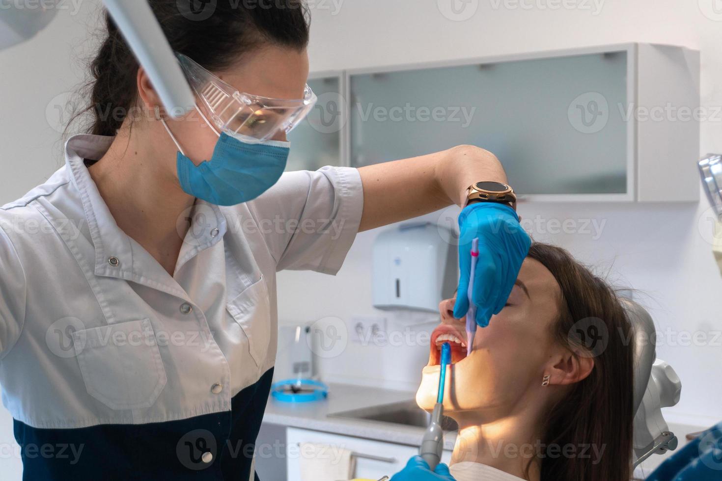 Zahnarzt behandelt einem Mädchen in einer Klinik Zähne foto