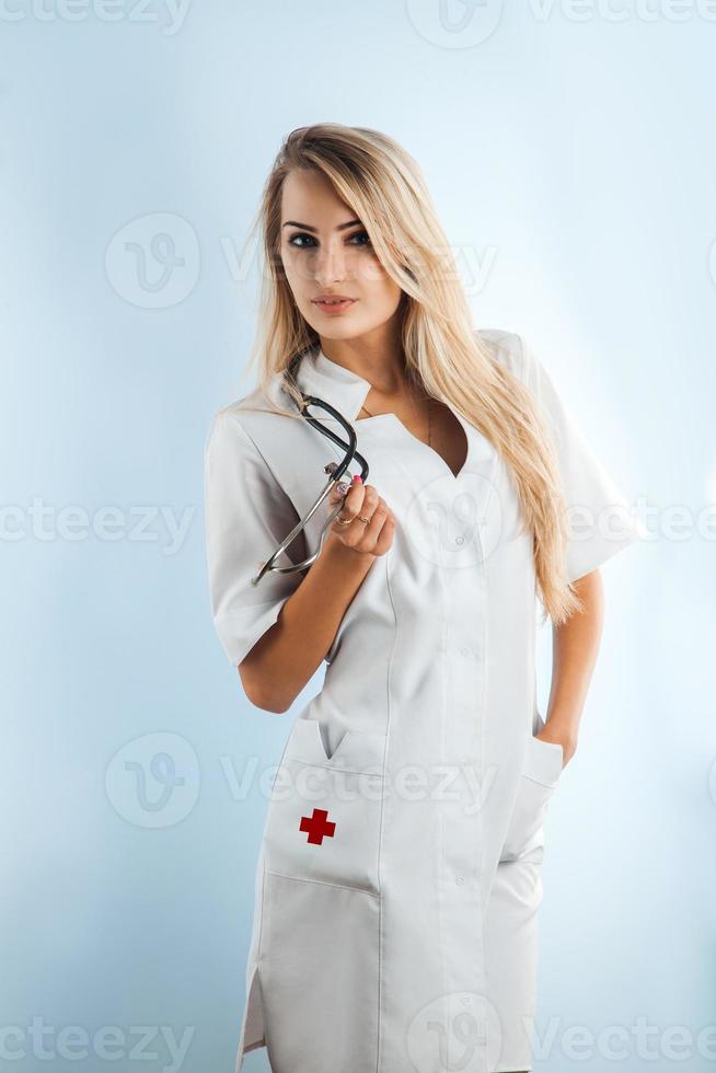 Farbbild der Schönheit blonde erwachsene Krankenschwester mit Stethoskop foto