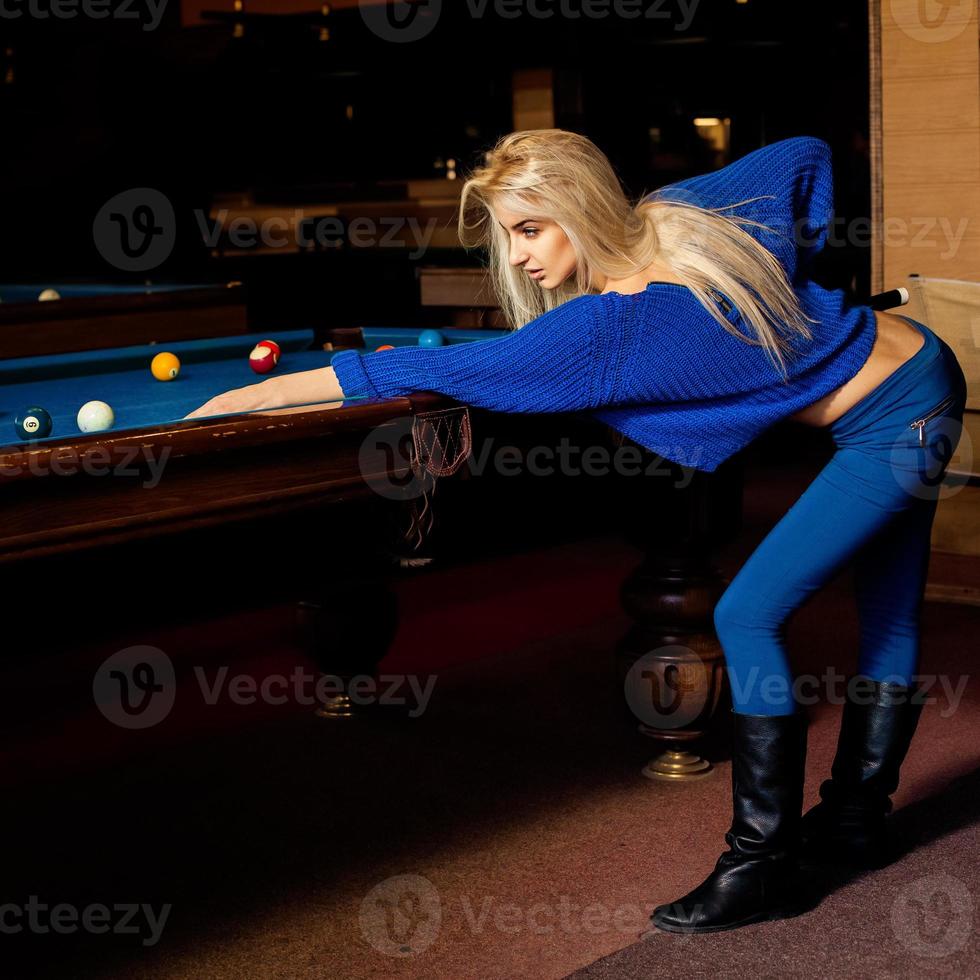 Porträt einer sexuellen blonden Frau mit Stichwort spielt Billard foto