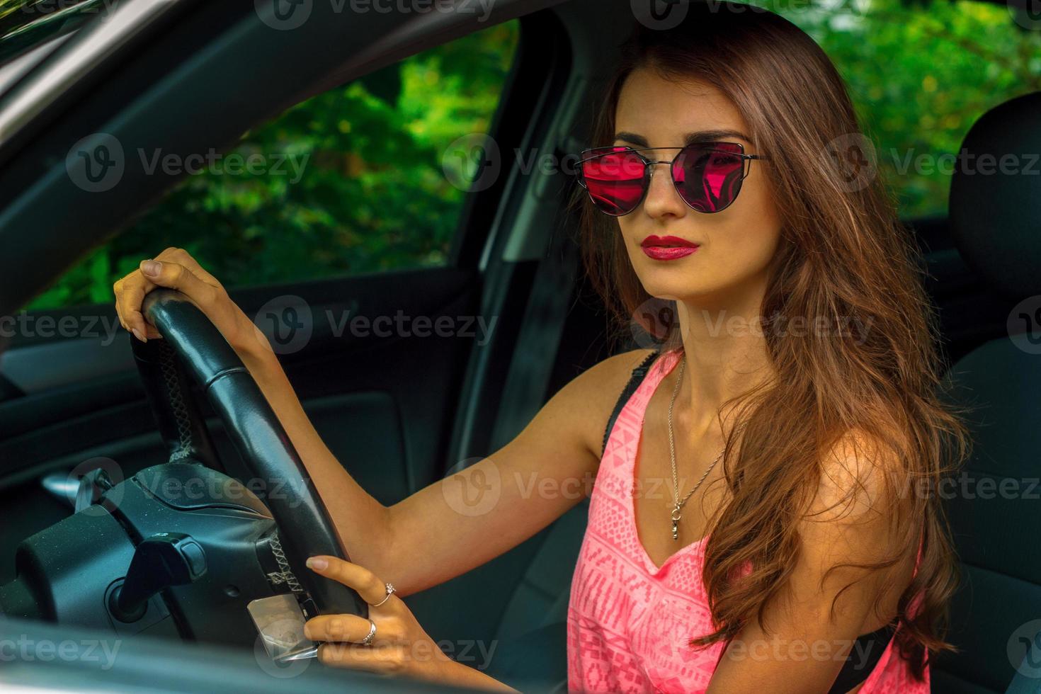 Porträt eines atemberaubenden jungen Mädchens mit verspiegelter Sonnenbrille zum Autofahren foto