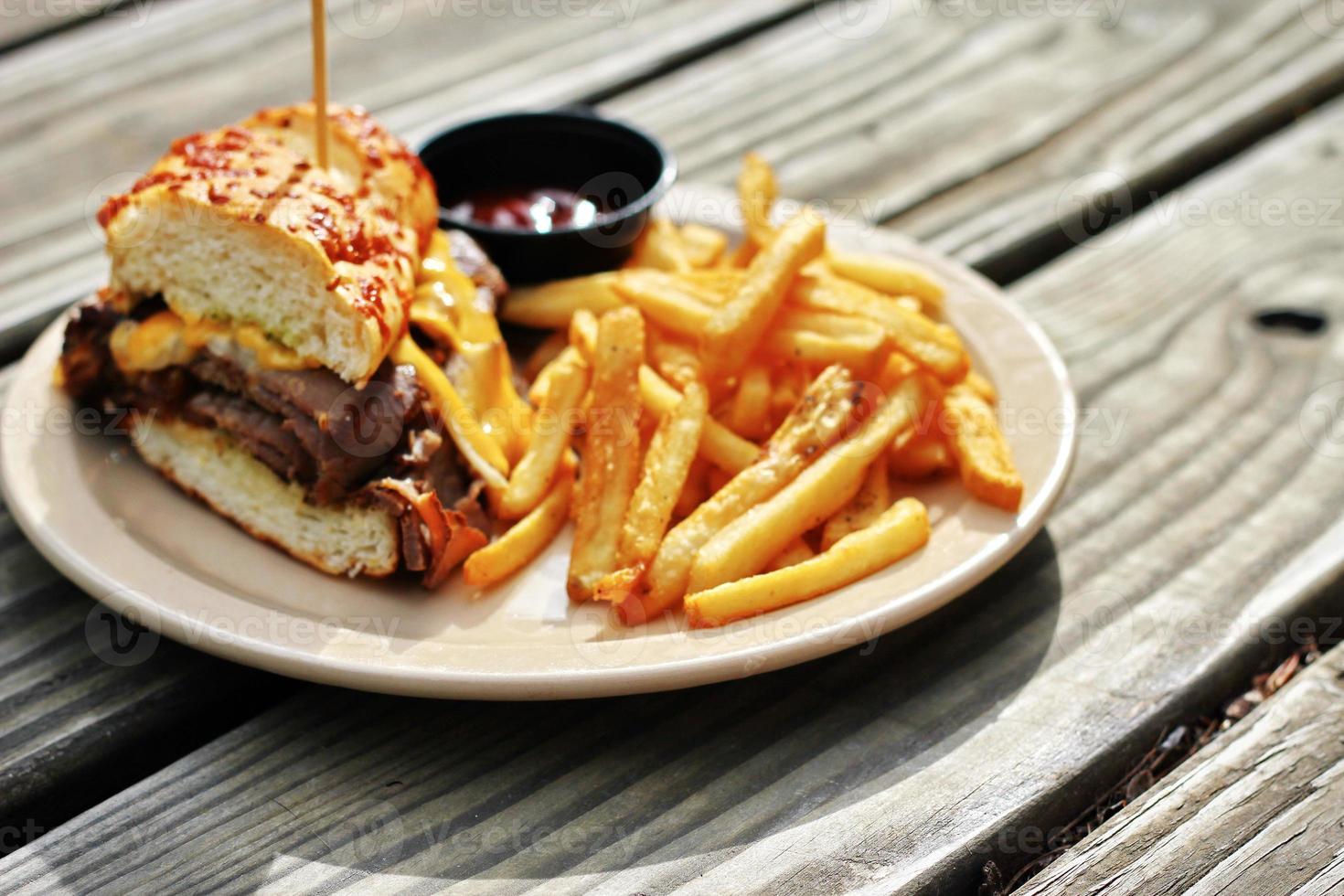 Das Prime Rib Dipper Food von Applebee's Restaurant wird auf einem braunen Holztisch serviert. sonniger Morgen foto