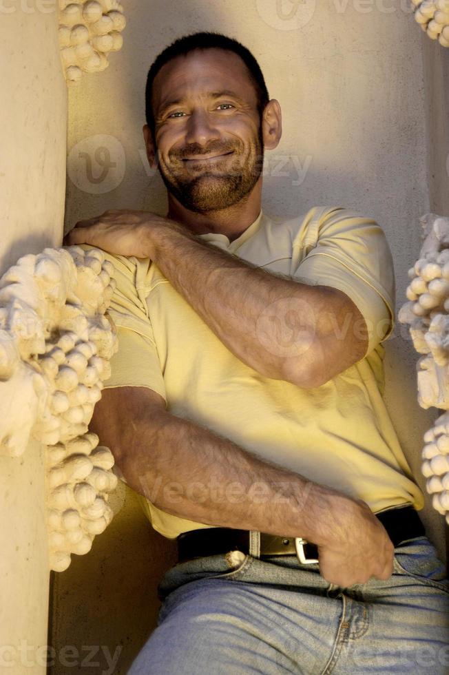 Ein glücklicher, lächelnder und attraktiver Mann posiert für ein verspieltes Porträt. foto
