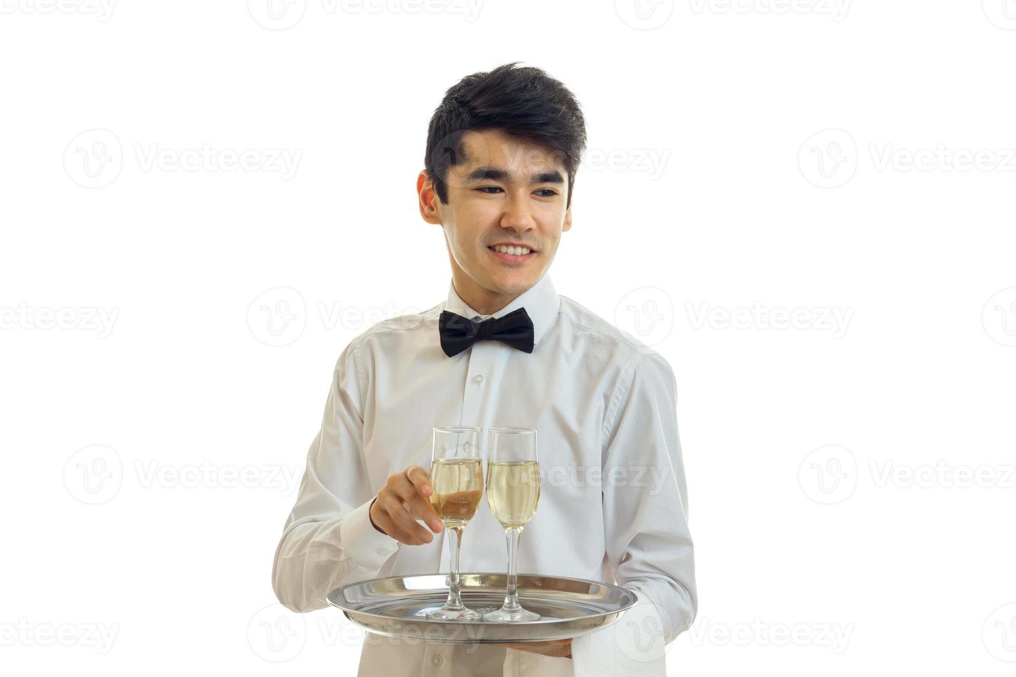 Porträt eines fröhlichen Kellners in einem weißen Hemd mit einem Glas Wein auf einem Tablett foto