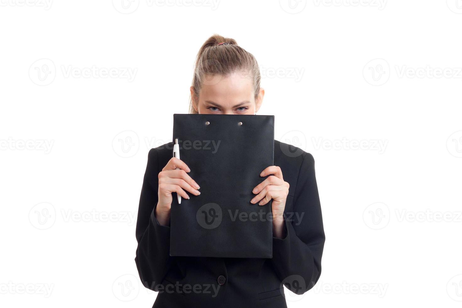 Geschäftsfrau in klassischer schwarzer Uniform verbirgt ihr Gesicht hinter einem Tablet foto