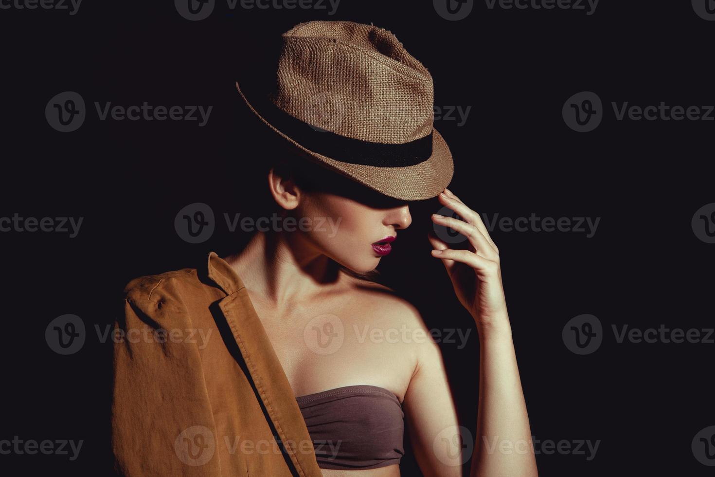 Nahaufnahmefoto einer sexy Frau mit schickem Hut auf schwarzem Hintergrund foto