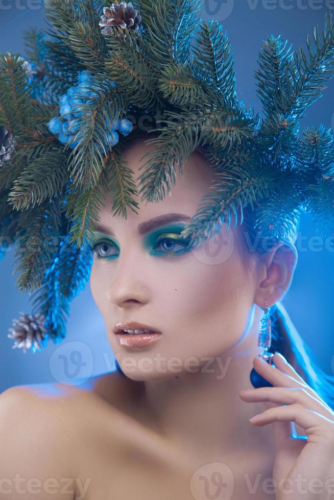 Weihnachtsporträt einer modischen jungen Frau mit Weihnachtskranz auf dem Kopf im Studio foto