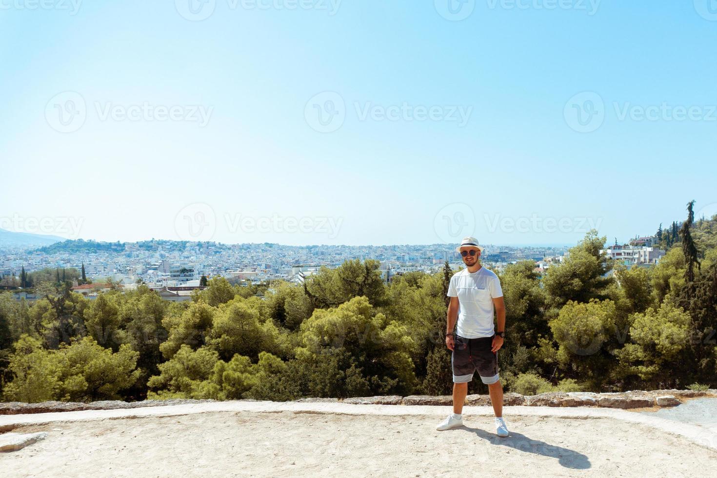 Guy steht auf dem Hügel mit Blick auf die Stadt foto