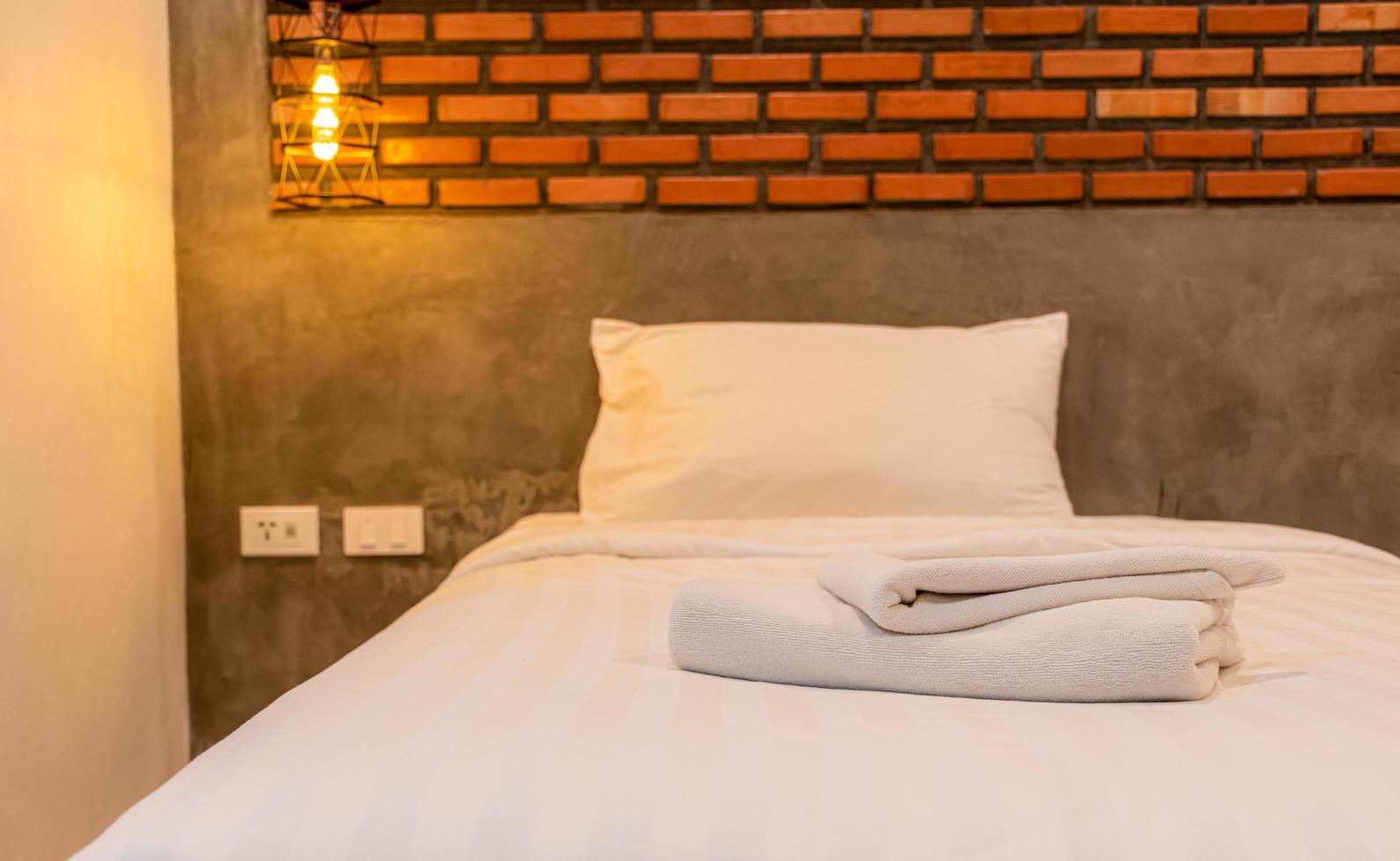 Nahaufnahme weiße Handtücher in den Schlafzimmern im Vintage- und Loft-Stil im Zimmer schmücken die Wände mit braunen Ziegeln. foto
