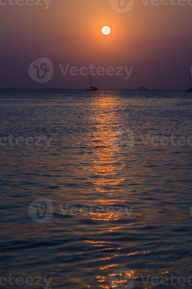 Sonnenuntergang über dem Meer mit Bootssilhouette foto