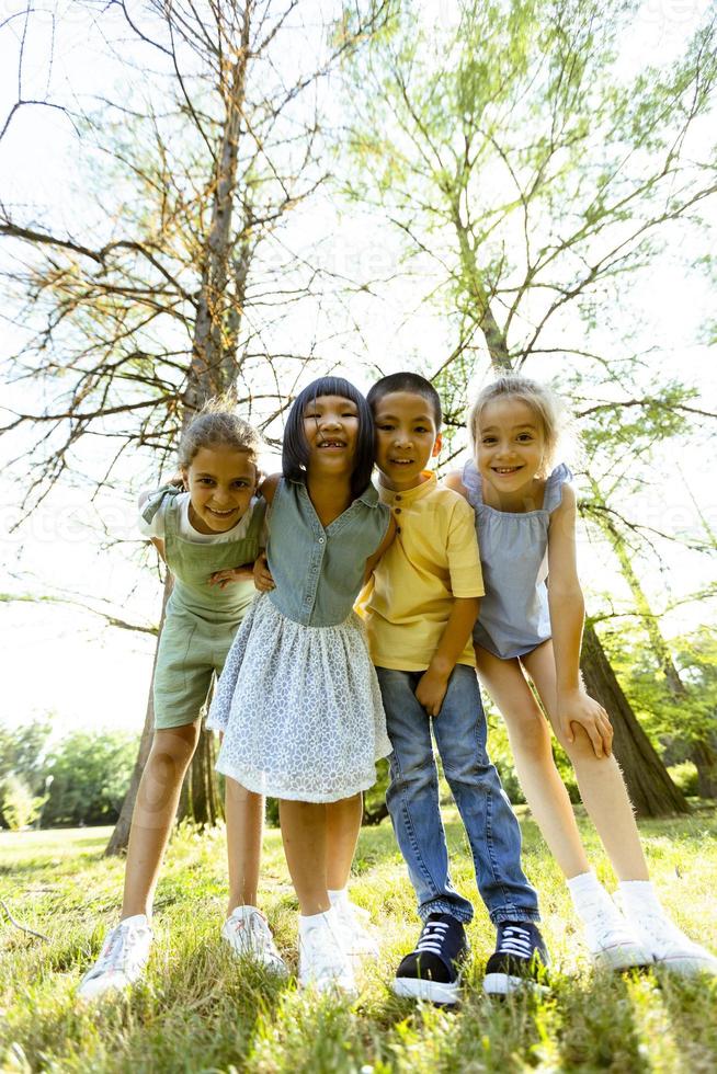 gruppe asiatischer und kaukasischer kinder, die spaß im park haben foto