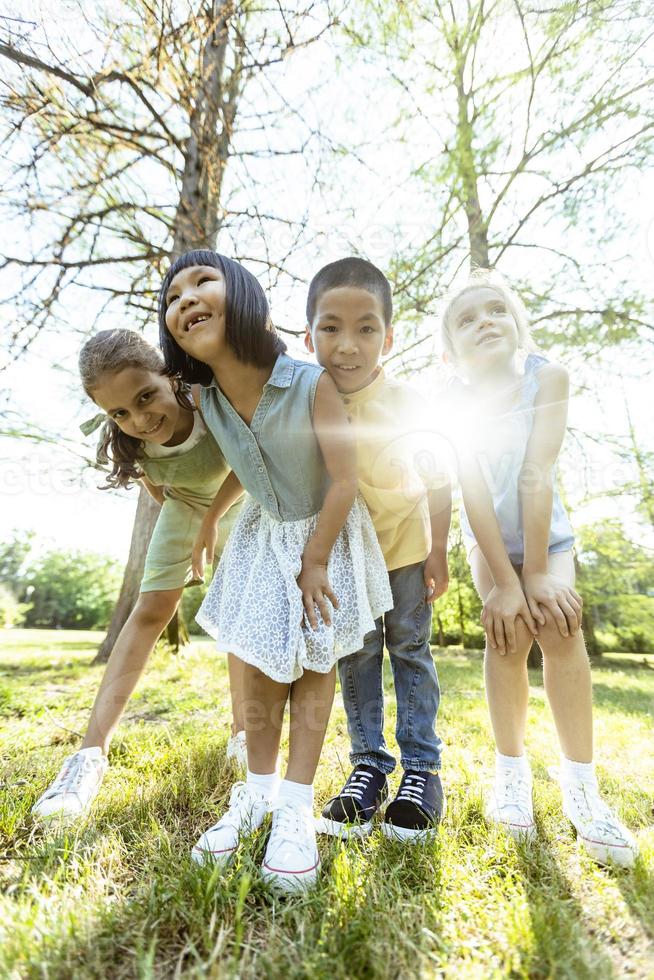 gruppe asiatischer und kaukasischer kinder, die spaß im park haben foto