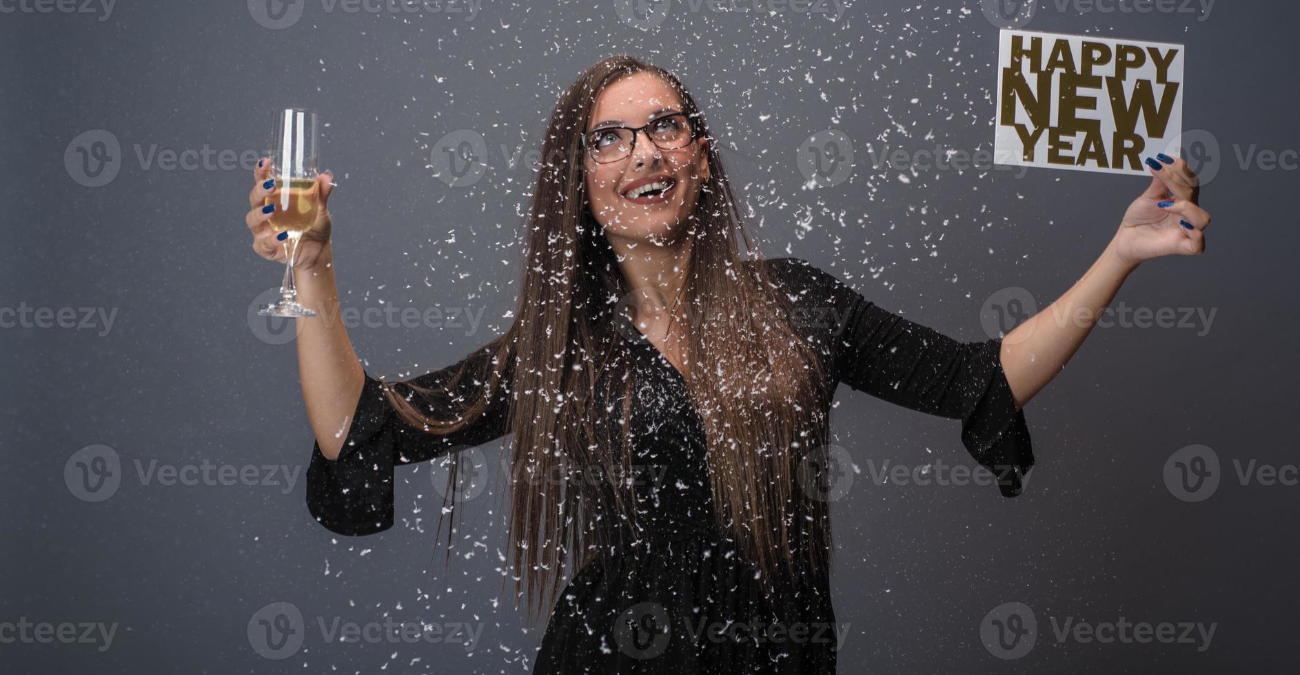 schöne frau, die neues jahr mit konfetti und champagner hält, die zeichen feiern. isoliert foto