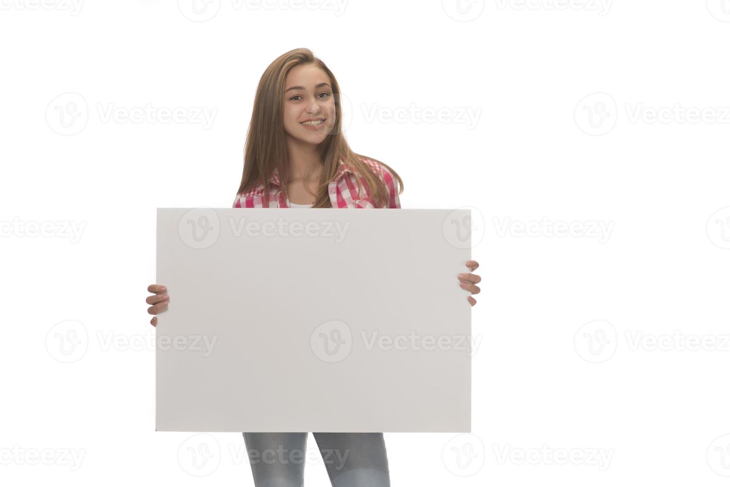 junge lächelnde frau, die ein leeres blatt papier für werbung hält foto