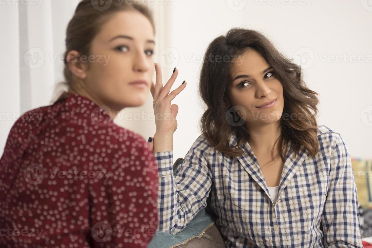 beste freunde, die spaß zu hause haben. junge frauen, die sich unterhalten. foto