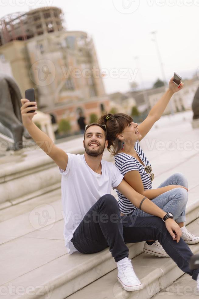 ein paar touristen, die spaß haben, im urlaub auf der straße der stadt spazieren zu gehen - glückliche freunde, die im urlaub zusammen lachen - menschen- und urlaubskonzept foto