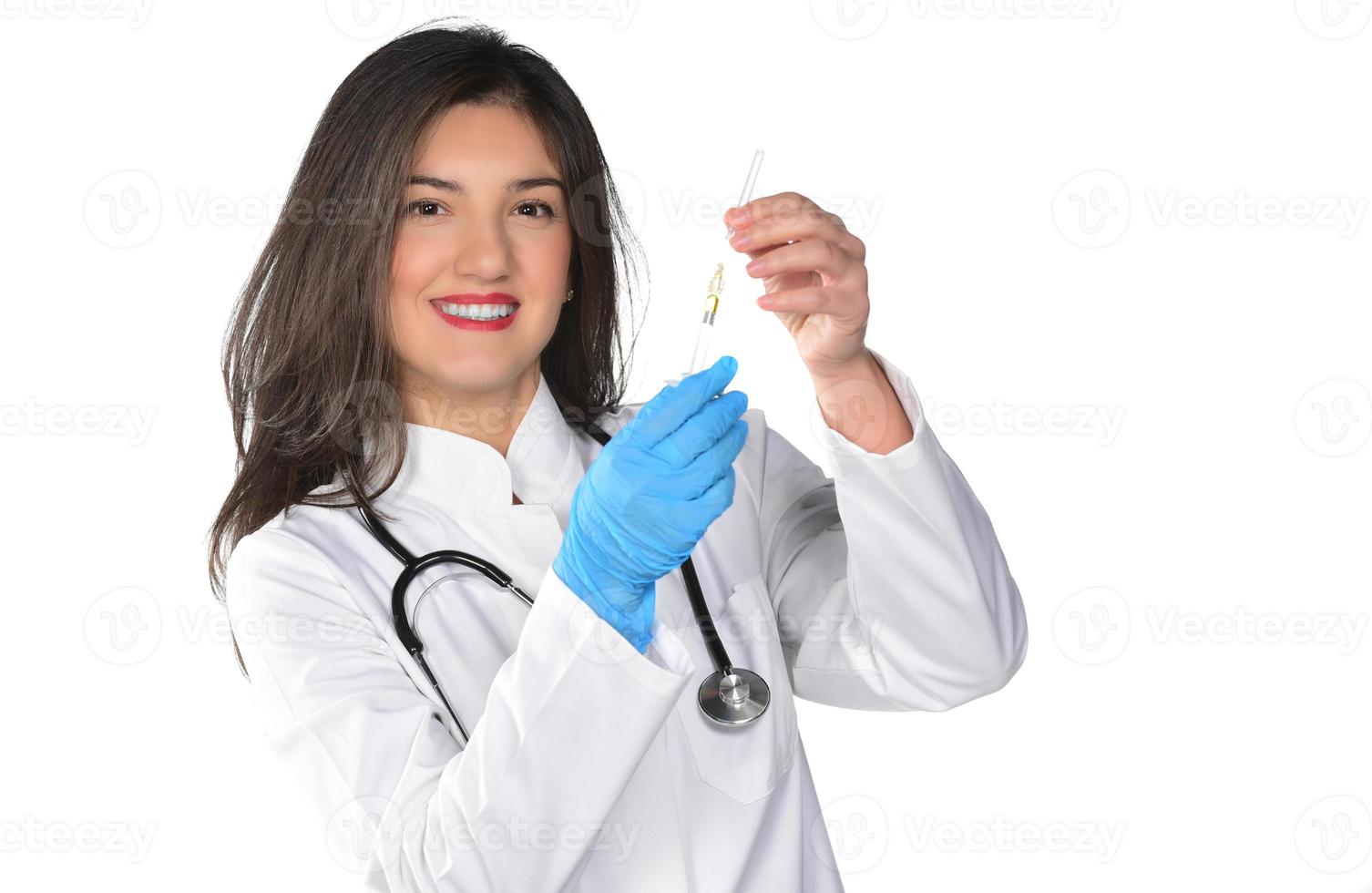 eine junge Ärztin mit Stethoskop bereitet eine Injektion vor, isoliert auf weißem Hintergrund foto