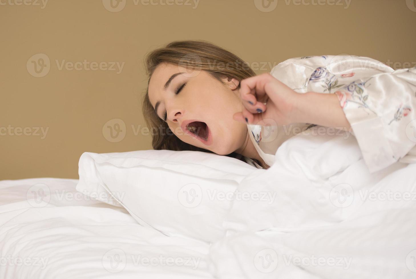 friedliche, ruhige, schöne junge dame trägt pyjamas, die schlafend liegen, entspannendes schlafen in einem gemütlichen weißen bett auf einem weichen kissen, das sich ausruht foto