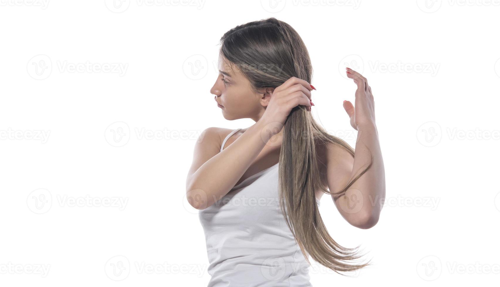 eine junge schöne frau band ihr haar mit einem gummiband zusammen foto