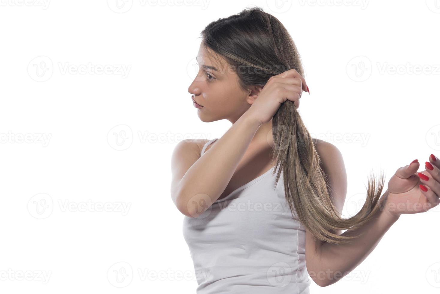 eine junge schöne frau band ihr haar mit einem gummiband zusammen foto