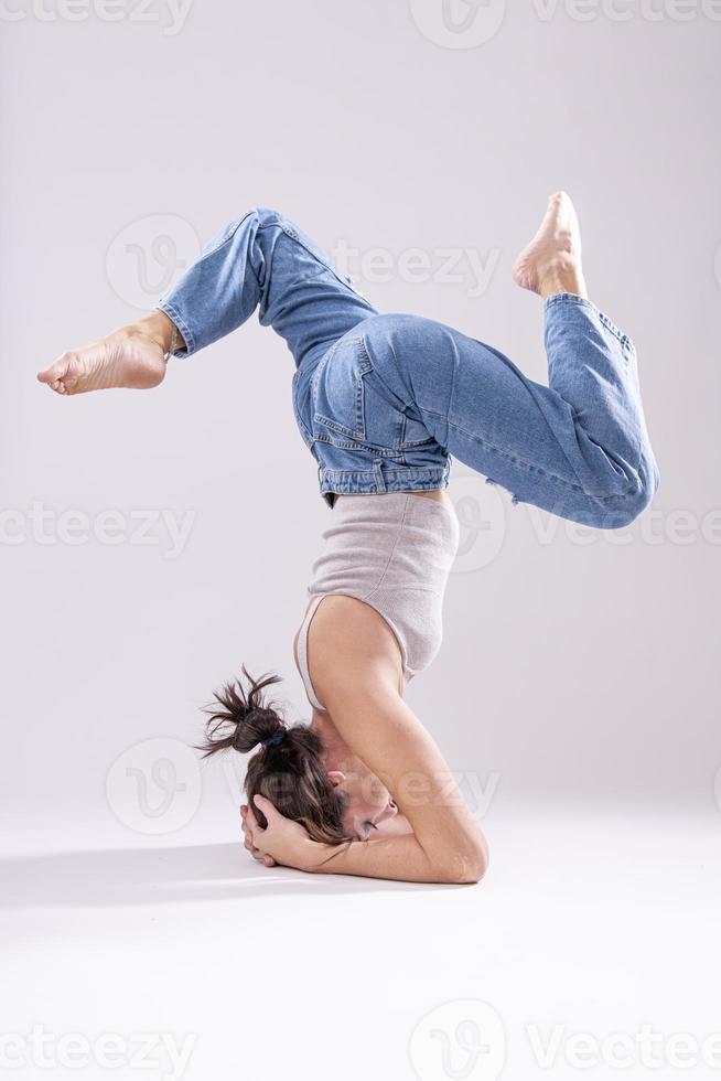 Porträt einer schönen jungen Frau mit athletischem, flexiblem Körper, die Beindehnung macht. isoliert foto