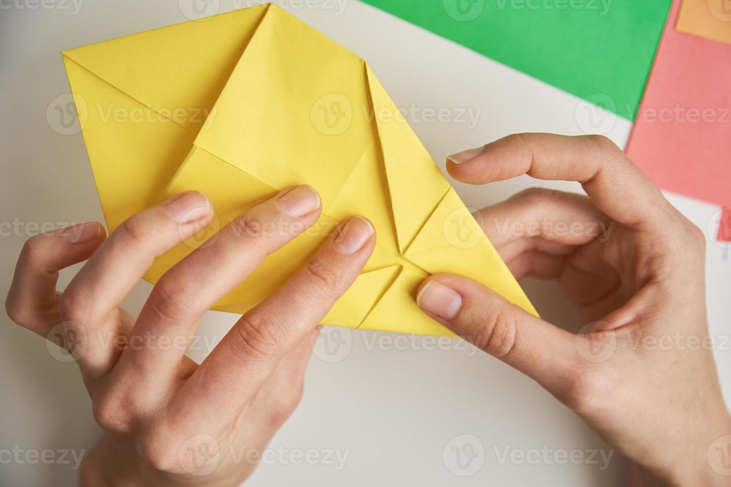 DIY-Konzept. Frau macht Origami-Osterhasen aus farbigem Papier. Origami-Unterricht foto