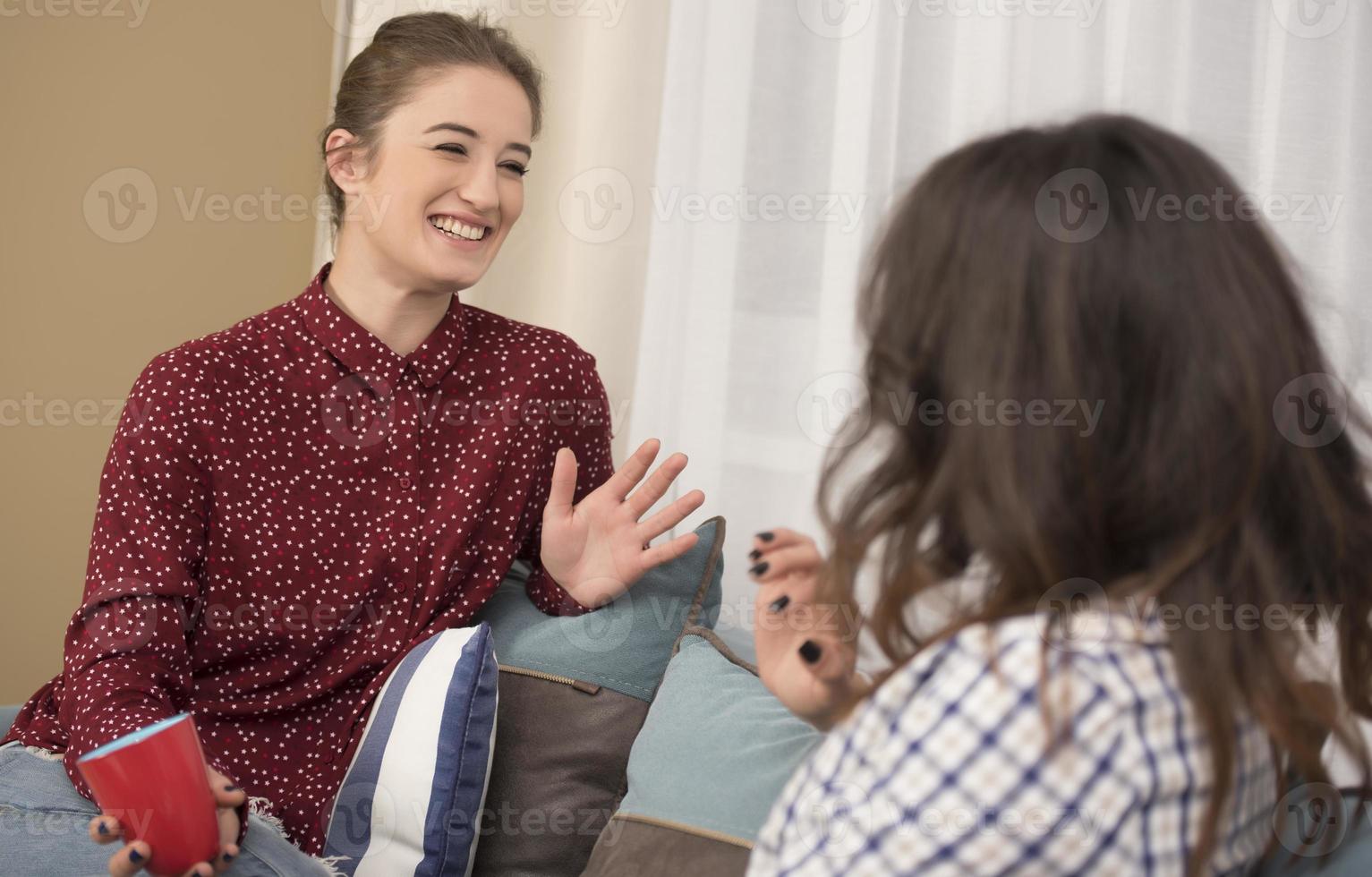 beste freunde, die spaß zu hause haben. junge frauen, die sich unterhalten. foto