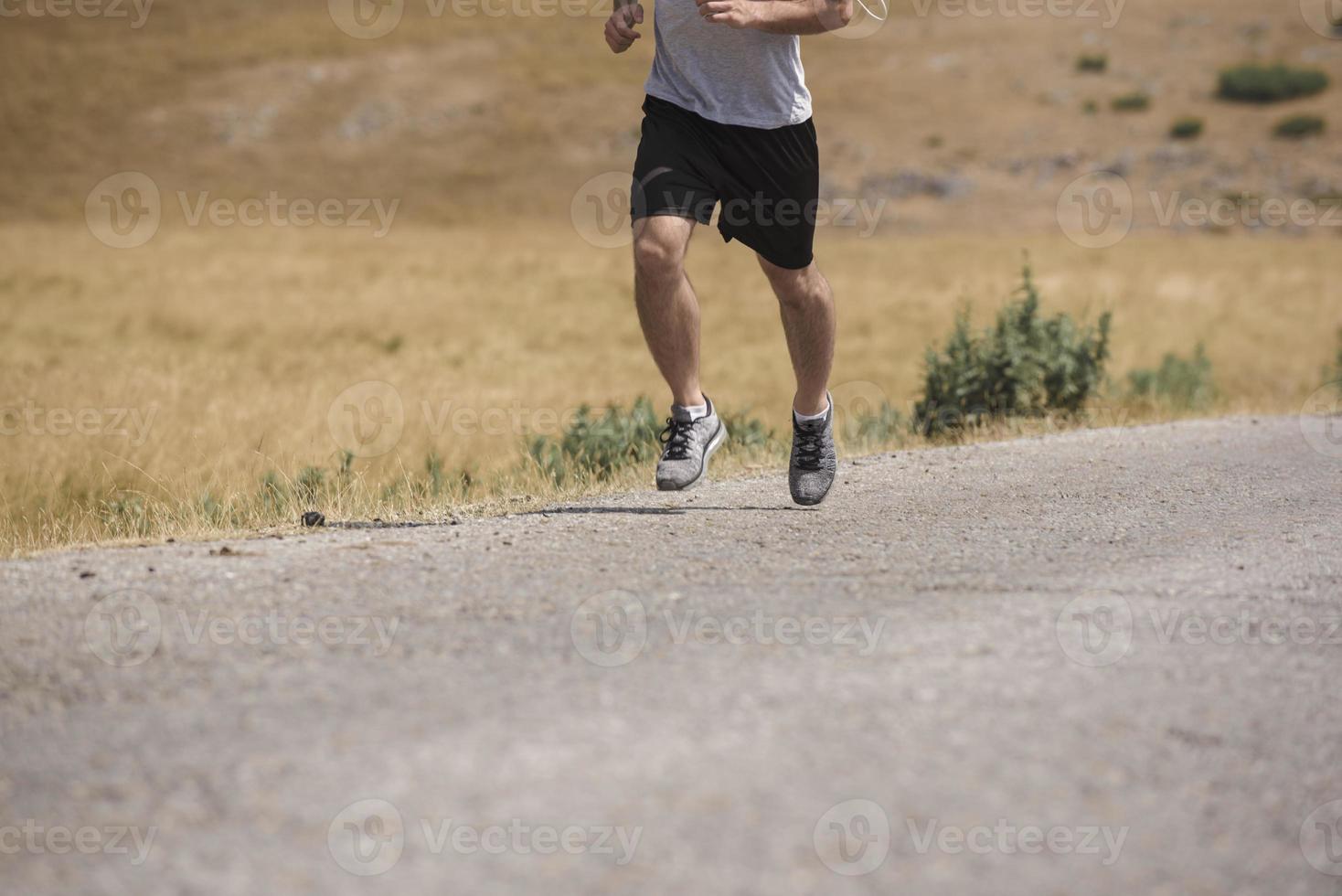 sportlicher Läufer, der im Sommer auf dem Bergplateau läuft foto