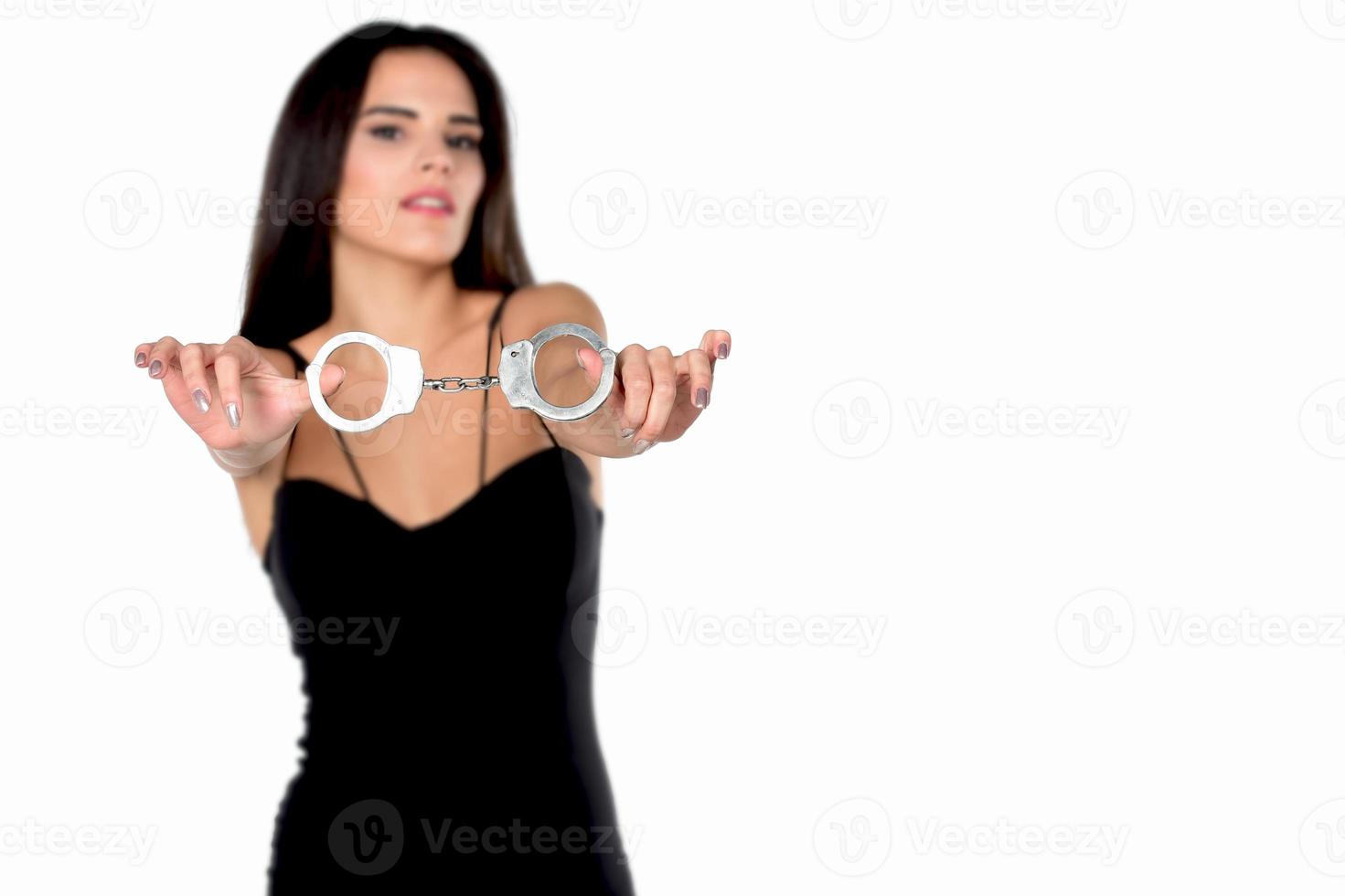 Frau, die Handschellen in ihren Händen hält foto
