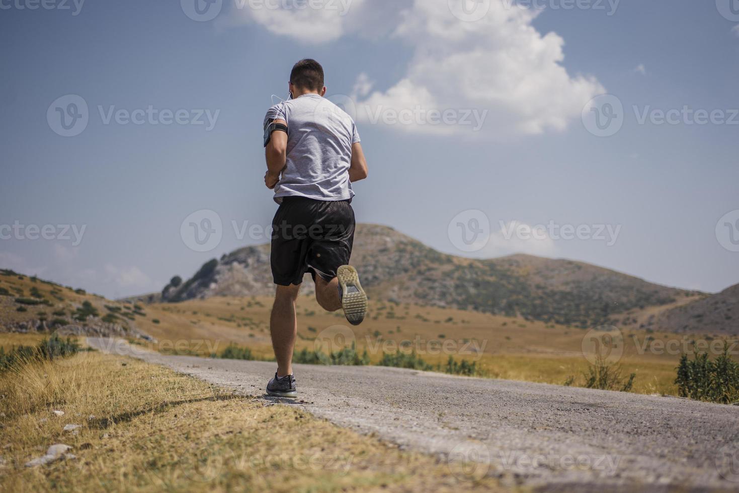 sportlicher Läufer, der im Sommer auf dem Bergplateau läuft foto