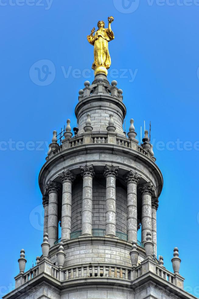 Civic Fame-Statue auf dem Gemeindegebäude in New York City, einem 40-stöckigen Gebäude, das gebaut wurde, um den gestiegenen Platzbedarf der Regierung nach der Zusammenlegung der fünf Bezirke der Stadt im Jahr 1898 zu decken. foto