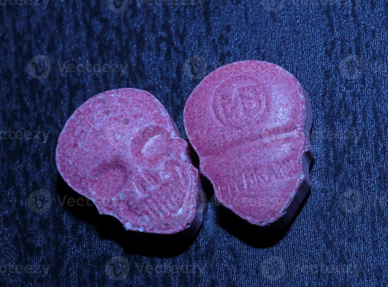 rosa schädel ecstasy pille nahaufnahme hintergrund hochwertiger druck lila armee dope betäubungsmittel substanz hochdosis psychedelische lebensart foto