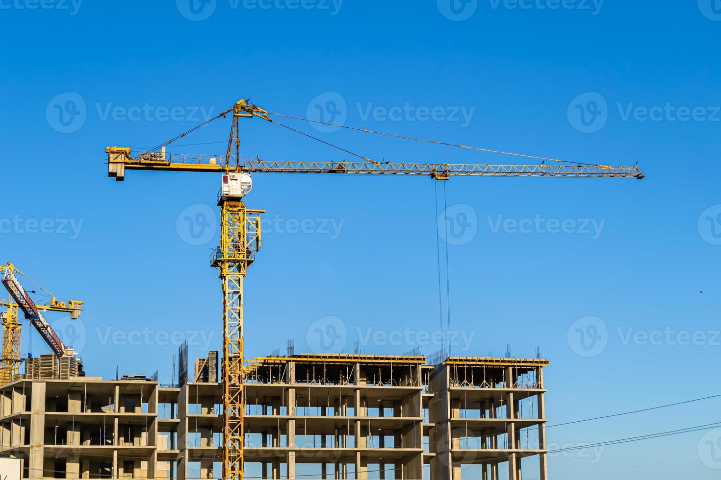 Großer Stahlkran auf der Baustelle des Wohngebäudes foto