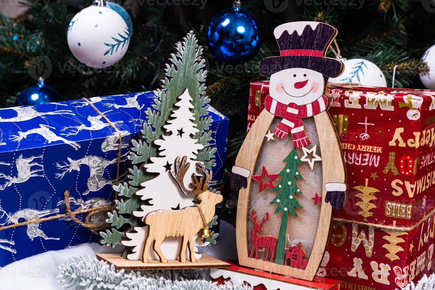 Weihnachtsschmuck vor verschwommenem Hintergrund. kleiner Schneemann aus Holz. rustikale hölzerne Schneemann-Schneeflocke Nahaufnahme eines glücklichen Schneemanns, der mit erhobenen Armen lächelt. Frohe Feiertage Grußkarte. foto