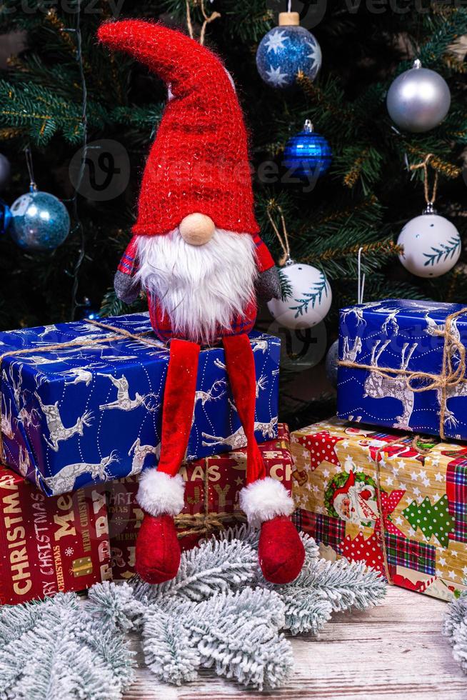 Weihnachtselfen Dekorationen. vier zwerge mit weihnachtsgeschenk sitzen auf einem holzregal. Weihnachts- und Neujahrskonzept, foto