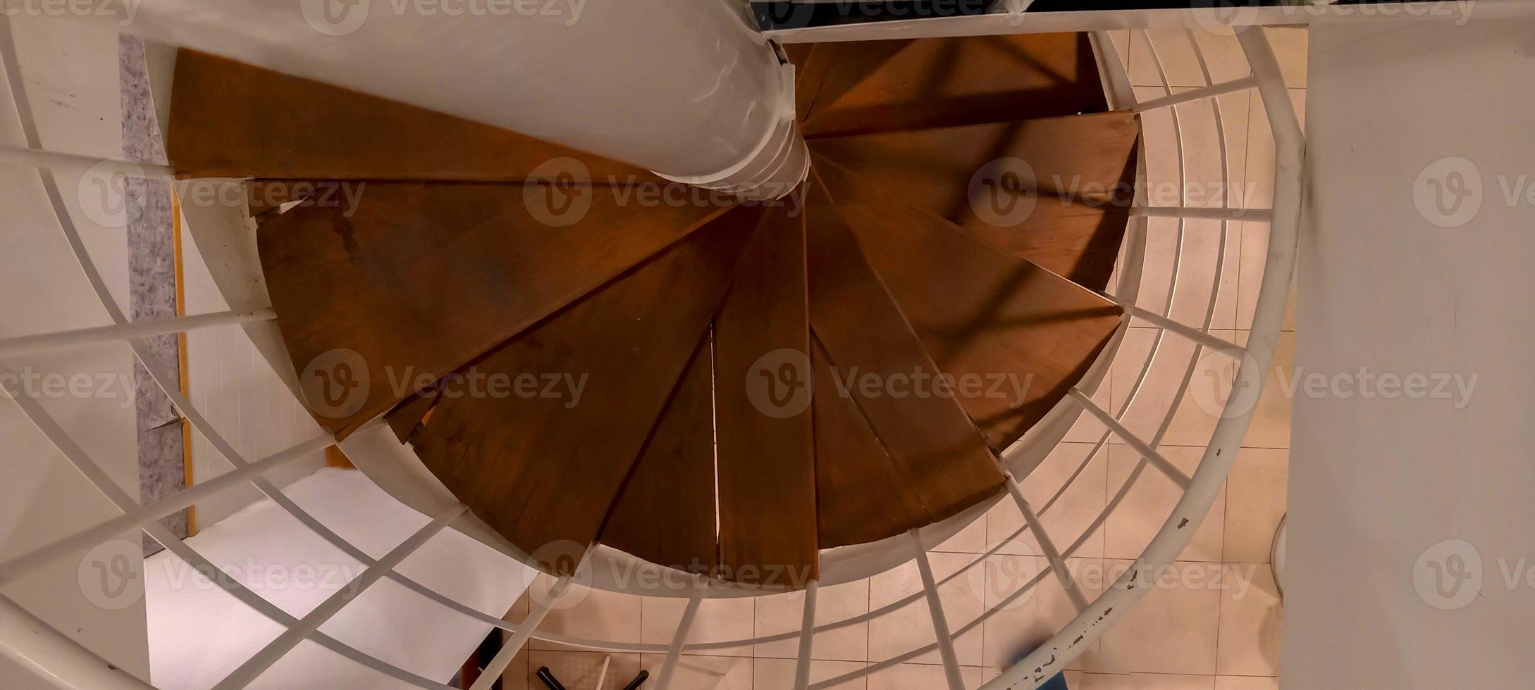 Wendeltreppe, von oben aufgenommen, wobei das weiße Treppengeländer zu sehen ist foto