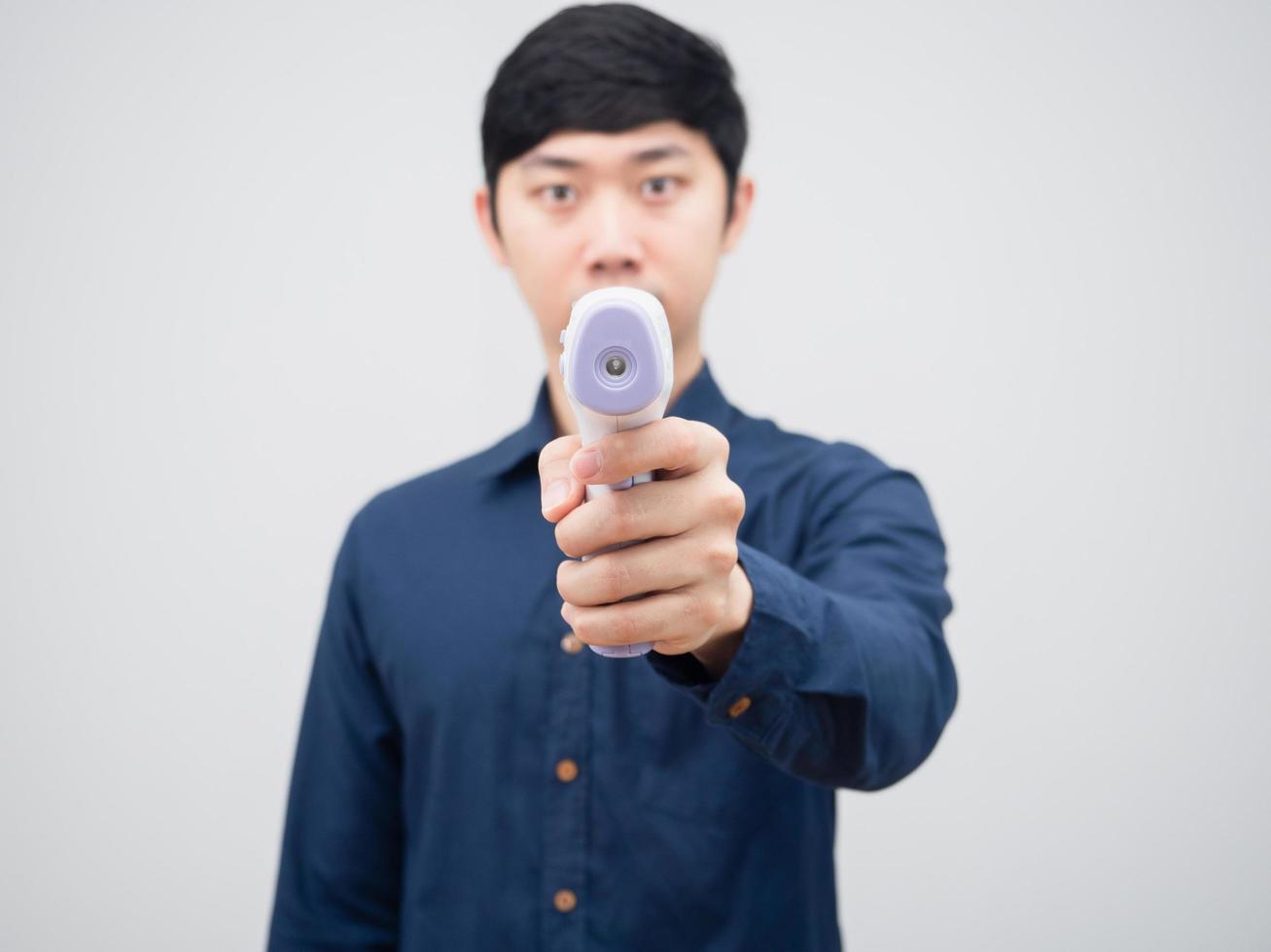 Closeup Infrarot-Thermometer in der Hand des Mannes auf weißem Hintergrund foto