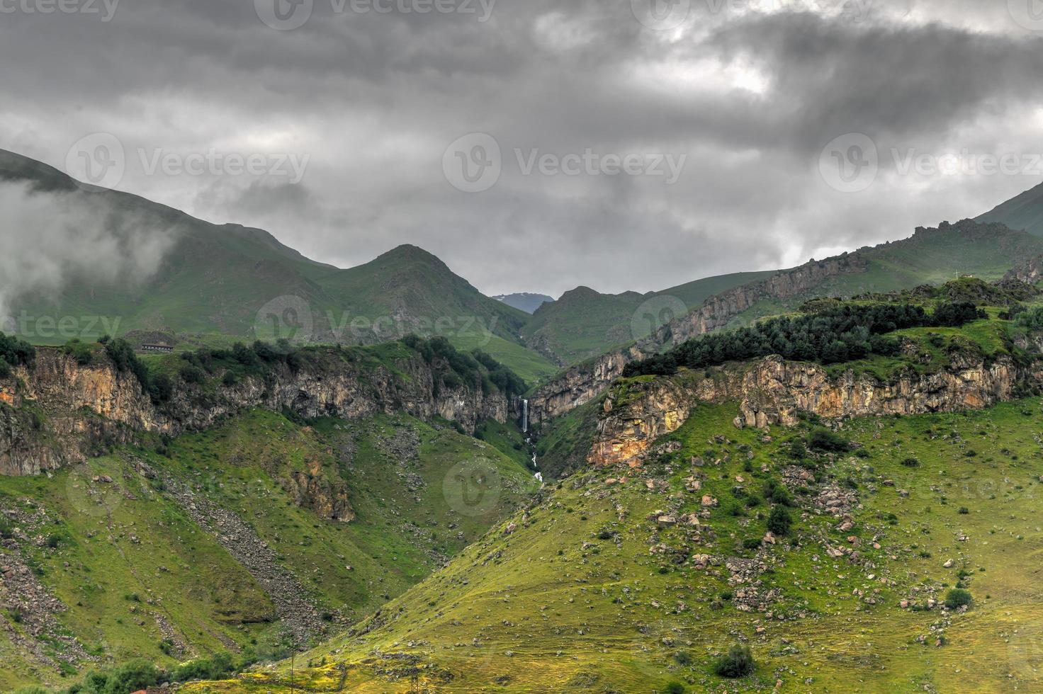 hügelige landschaft in der nähe des dorfes gergeti in georgia, unter dem berg kazbegi. foto