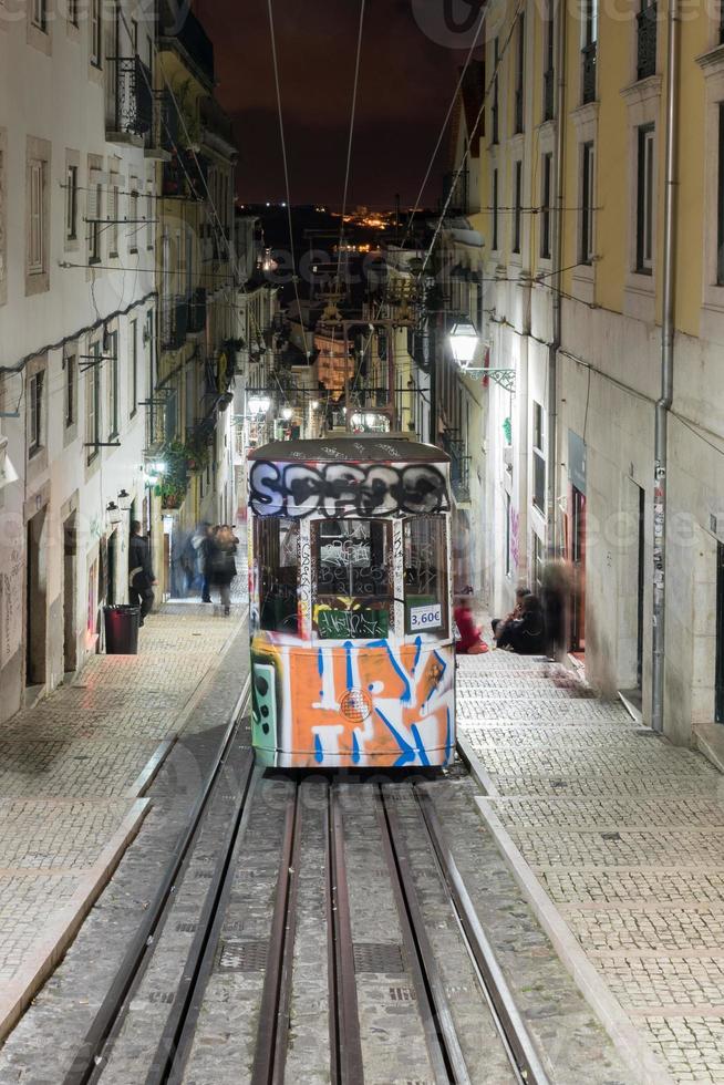 vintage berühmte bica straßenbahn nachts mit graffiti in lissabon, portugal. foto