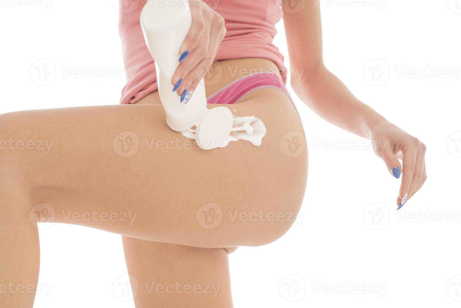 Körperpflege. Frau, die Creme auf die Beine aufträgt. Frau, die Anti-Cellulite-Creme aufträgt foto