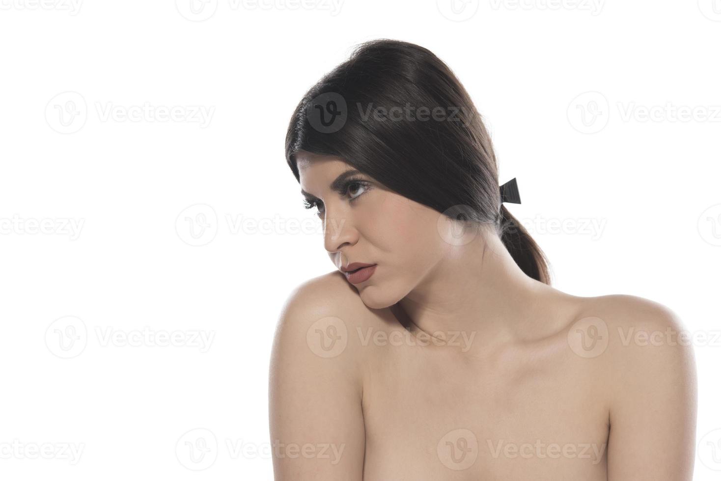 sinnliche Frau mit schönem schwarzem glänzendem Haar und schöner Haut, die im Studio auf weißem Hintergrund aufwirft foto