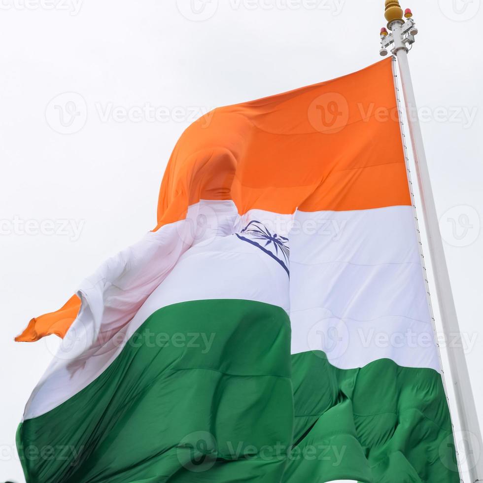 Indien-Flagge, die hoch am Connaught-Platz mit Stolz auf den blauen Himmel fliegt, Indien-Flagge flattert, indische Flagge am Unabhängigkeitstag und Tag der Republik Indien, Schuss nach oben geneigt, indische Flagge schwenkend, Har Ghar Tiranga foto